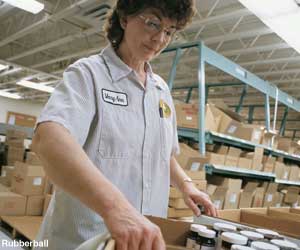 Photo: Female factory worker assembling bottles in boxes