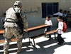 A U.S. Army soldier helps local Iraqi school students move furniture into the school courtyard during a combined medical effort in Bata, Iraq, March 17, 2008. The soldier is assigned to the 25th Infantry Division's 2nd Squadron, 14th Cavalry Regiment.