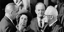 Lyndon B. Johnson being sworn in as President of the U.S. by Chief Justice Earl Warren as Lady Bird Johnson and Hubert Humphrey look on.