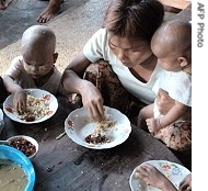 Cyclone-affected children are served food in Shwepoukkan area of Rangoon, 25 May 2008