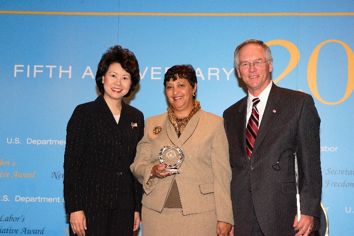 Secretary of Labor Elaine L. Chao (L) and Assistant Secretary of Labor for Disability Employment Policy W. Roy Grizzard (R) present a 2006 Secretary of Labor's New Freedom Initiative Award to Cheryl E.H. Locke, Chief Human Resources Officer, The RAVE Program, University of Alabama at Birmingham. (DOL Photo/Shawn Moore)