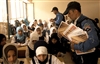 Iraqi National Police hand out school supplies to children inducted in the Junior Hero Program at a school in the Meshahadah province of Iraq, March 16, 2008. 