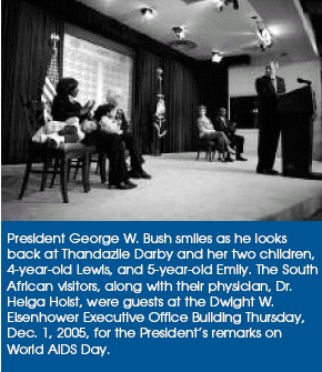 President George W. Bush smiles as he looks back at Thandazile Darby and her two children, 4-year-old Lewis, and 5-year-old Emily. The South African visitors, along with their physician, Dr. Helga Holst, were guests at the Dwight W. Eisenhower Executive Office Building Thursday, Dec. 1, 2005, for the President’s remarks on World AIDS Day.