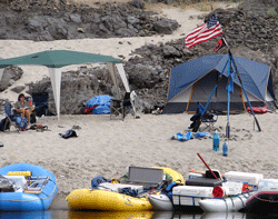 [Photo] Tents and US Flag flying next to river with rafts