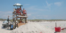 Lifeguard stand and rescue buoys are stationed on the beach.