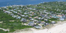 Aerial view of small community, Kismet, looking from the southwest, bay to the upper left and sandy beach to the lower right.