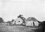 Two ramshackle buildings in a remote landscape.