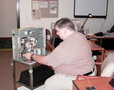 Image of a man working on the insides of a computer