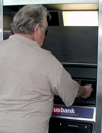 Image of a man using an ATM machine.