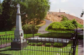 Gray memorial and Great Grave with trail to top of hill in background. Whitman memorial at top of hill.