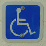 Accessibility logo: stylized drawing of a person in a wheelchair.