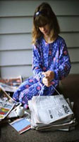 Photo of girl tying up newspapers 