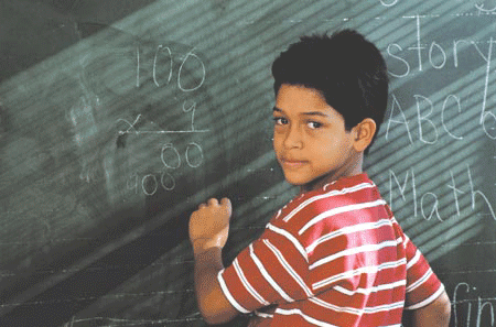 Boy writing on chalkboard photo