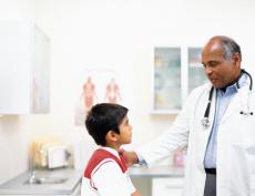 Fotografía de un doctor hablando con un niño en un cuarto de examen