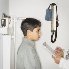 Fotografía de un doctor midiendo la estatura de un niño