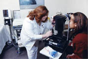 A health care professional examines a patient's eyes