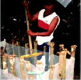 Photo of a man stirring the solution in a small plastic-lined pit.