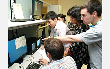 Photo shows Exotic Beam Summer School students viewing progress of their experiments.