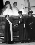 Three women standing near a sculpture of three women.