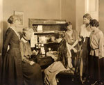 A group of women gathered around a desk.
