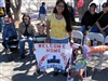 Diana Garcia, with 4-year-old son Rolando Garcia Jr. and 1-year-old daughter Jocelynn Garcia, pays tribute to her husband, Army Spc. Rolando Garcia, by holding up a sign during a soldiers' homecoming parade in El Paso, Texas, Feb. 27. Her husband is assigned to the 27th Brigade Support Battalion.