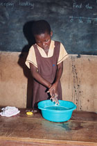 Girl washes hands in wash basin. Photo courtesy of Photoshare.