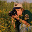 A woman photographing prairie flowers in the early morning.