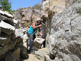 A quarrier is breaking up stone in his quarry