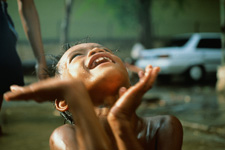 Child looking up towards the sky on a rainy day.