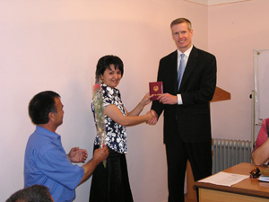 USAID's representative hands over the completion certificate to one of the graduates