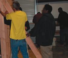 Image of multiple people framing a house