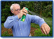 Man spraying DEET over clothing