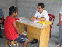 A young boy is interviewed by a health-care worker as part of CDC activities in Iquitos, Peru. Courtesy: RAVREDA