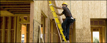 Photo: A contruction worker climbing a ladder.