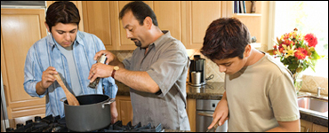 Foto: un padre y sus hijos preparando una comida.