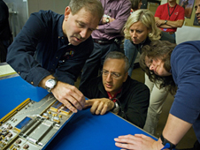 Astronauts John Grunsfeld (left) and Mike Massimino inspect position indicator decals on the STIS replacement printed circuit board