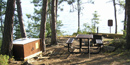 A small campsite on Rainy Lake has a food locker, picnic table, tent pad sites, fire ring and a privy.