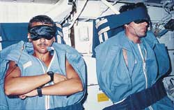 To sleep aboard a spacecraft, astronauts can zip themselves into sleeping bags strapped to the wall. Blindfolds block the sunlight that streams in the windows periodically during orbit.