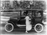 [Side view of a Ford sedan with four passengers and a woman getting in on the driver's side]
