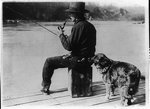 [Hooch Hound, a dog trained to detect liquor (as suggested to Commissioner Haynes by a prohibition agent in Colorado), sniffs at flask in back pocket of man, seated, fishing on pier on the Potomac River]
