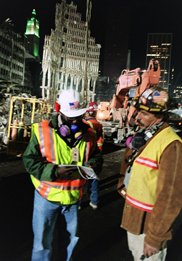 Two recovery workers in front of the World Trade Center debris.