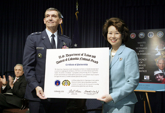 Secretary of Labor Elaine L. Chao (right) and Maj. Gen. David Wherley (center), Commanding General of the District of Columbia National Guard celebrate the adoption of the D.C. National Guard by the U.S. Department of Labor on Friday, November 14, as Secretary of Veterans Affairs Anthony J. Principi (left) looks on. 