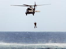 Rescue helicopter hovers over Atlantic Ocean.