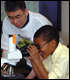 Camper and leader looking at bacteria under microscope