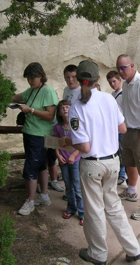 Image of a volunteer talking with visitors on the trail
