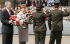 President Bush and Latvian President Vike-Freiberga stand holding wreaths as two soldiers walk by saluting at Freedom Monument ceremony, Riga, Latvia, May 7, 2005. White House/Paul Morse.