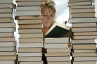Image: Stacks of books with woman in the middle.