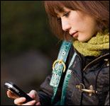 Photo: A young woman reading a text message.