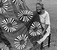 Fannie Lee Teals with her red, white and blue American Revolution Bicentennial quilt, 1977