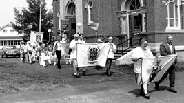 Following the "Acadian Mass," members of St. David Church in St. David, Maine, carry family banners to the place on the St. John River where Acadians first landed in the region